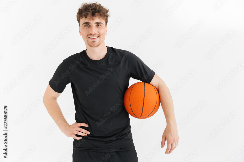 Photo closeup of joyful young man in t-shirt smiling and holding ball while playing basketball game Photo closeup of joyful young man in t-shirt smiling and holding ball while playing basketball game