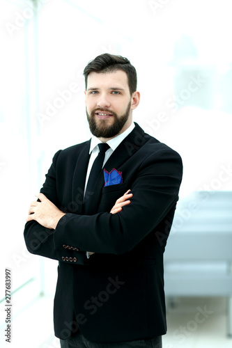 confident businessman standing near the office window