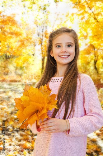Autumn portrait of adorable smiling  little girl child with leaves