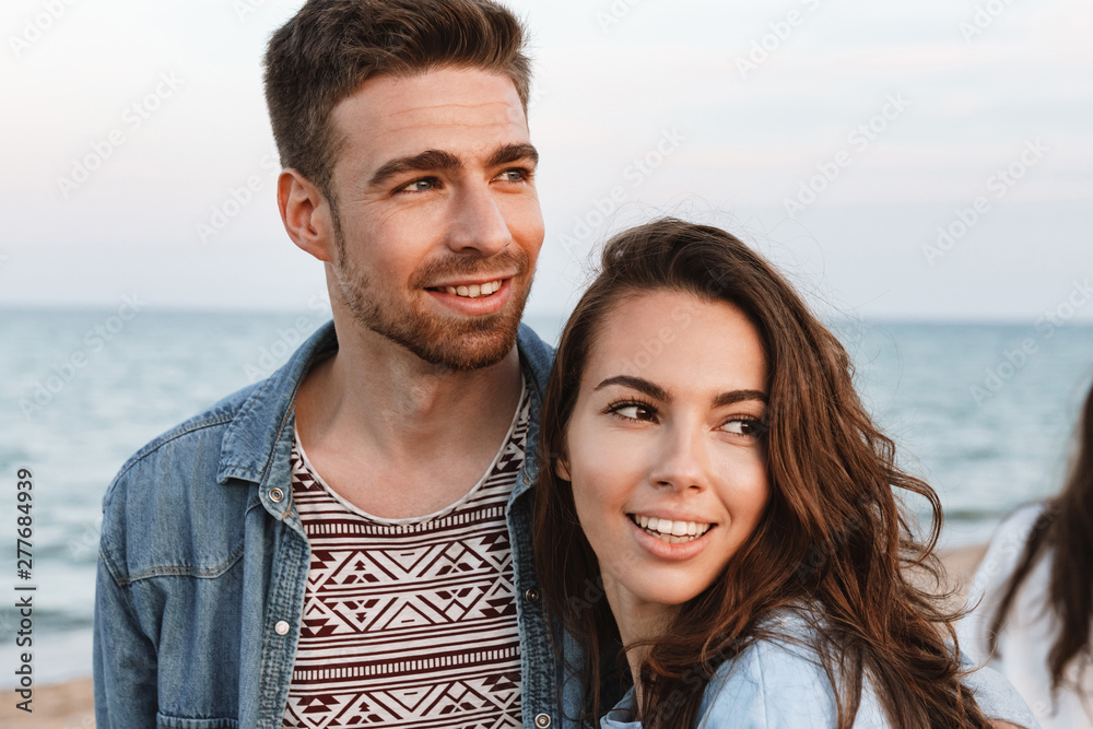 Beautiful young smiling couple spending time at the beach Beautiful young smiling couple spending time at the beach