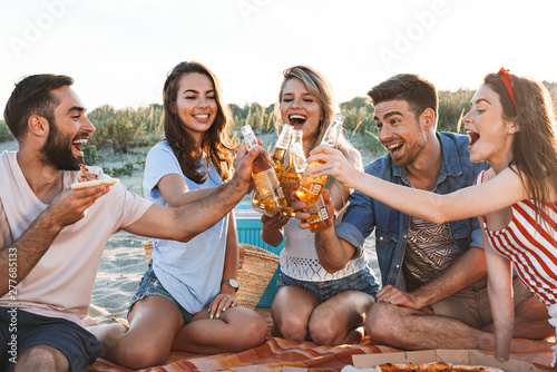 Group of happy friends spending time together at the beach