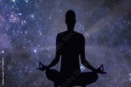 Blur background, no focusing -Abstract image for the background.Milky Way. Night sky with stars and silhouette of a man practicing yoga.