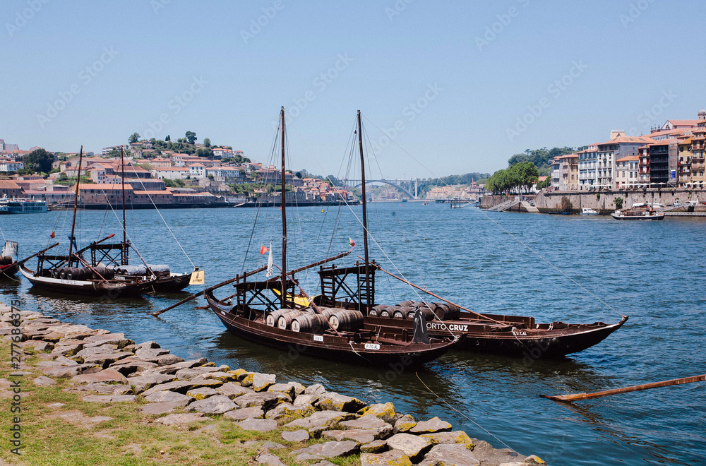 Riverboats with wooden barrels with port wine, old boats from some wineries on river Douro. Porto city.