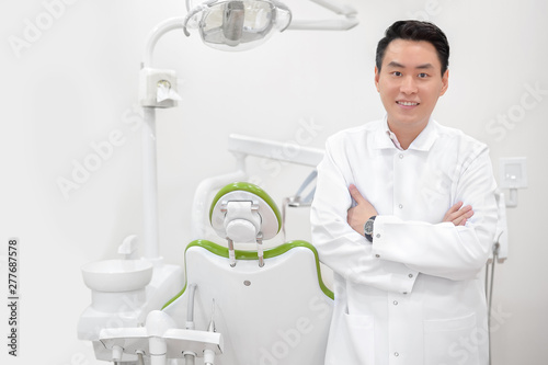 Attractive male distist smile in his dental clinic photo