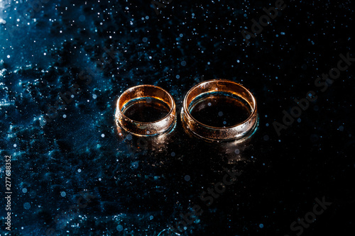 Beautiful wedding gold rings on dark background