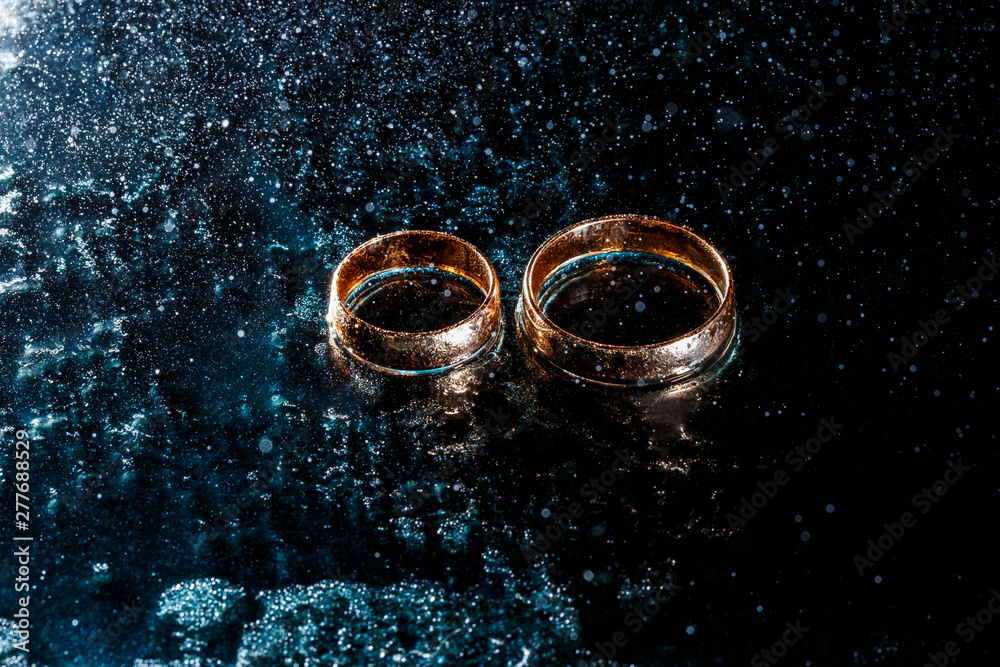 Beautiful wedding gold rings on dark background Beautiful wedding gold rings on dark background
