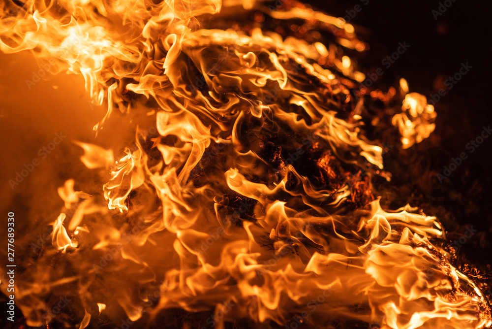 Large burning fire with soft glowing flame and sparkling around.Fire flames on black background Large burning fire with soft glowing flame and sparkling around.Fire flames on black background