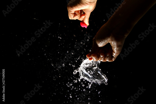 Popping water balloon on black background