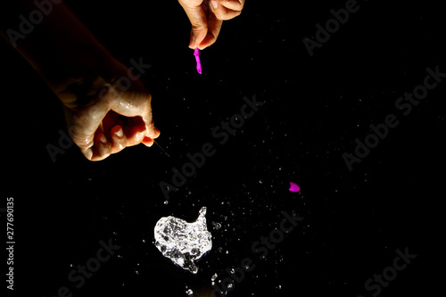 Popping water balloon on black background
