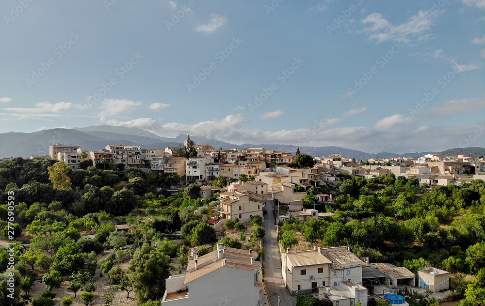 Aerial photo drone point of view image Campanet town hillside residential old ancient houses building exterior situated in the northeast of Majorca Island, Spain,