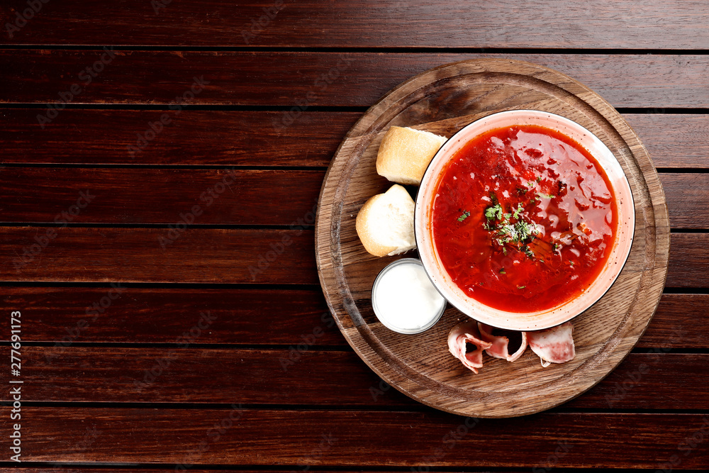 borsch with bacon and pampushkas on a wooden board on a brown wooden background borsch with bacon and pampushkas on a wooden board on a brown wooden background