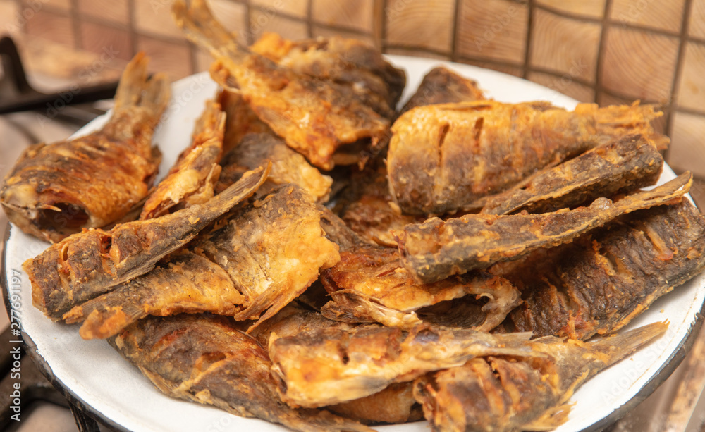 Fried fish in a pan in the kitchen