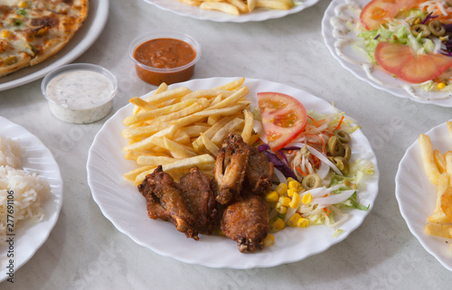 Plate of chicken wings with chips and salad