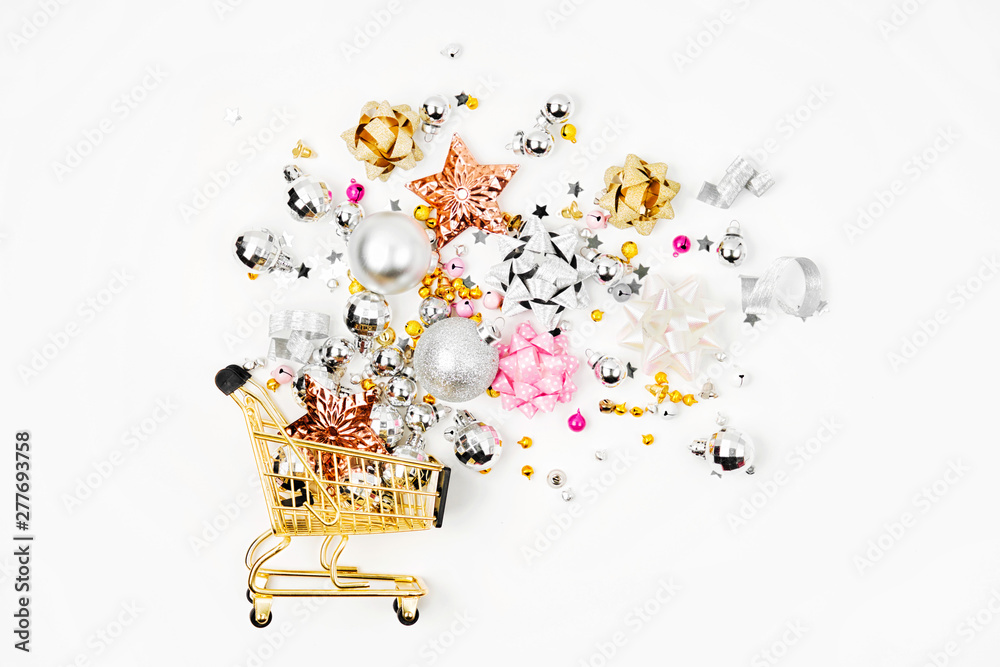 Shiny Christmas decorations  in a shopping cart on a white background. Christmas Shopping concept. Flat lay, top view