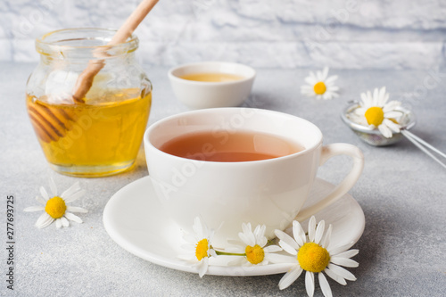 Fototapeta Naklejka Na Ścianę i Meble -  cup of herbal tea with chamomile flowers on grey table. Copy space