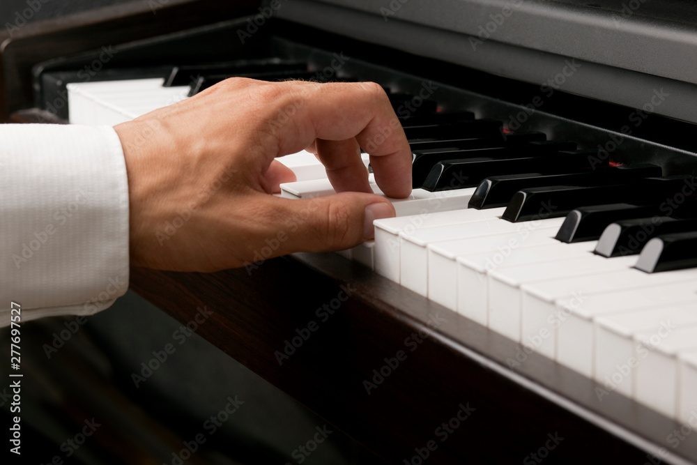 Fototapeta premium Männliche Hand spielt am Klavier