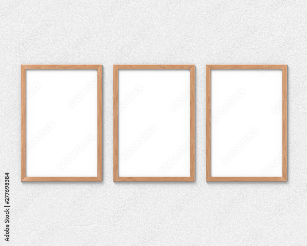 Set of 3 vertical wooden frames mockup with a border hanging on the wall. Empty base for picture or text. 3D rendering.
