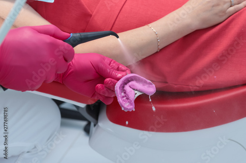 the dentist washes the impression with water