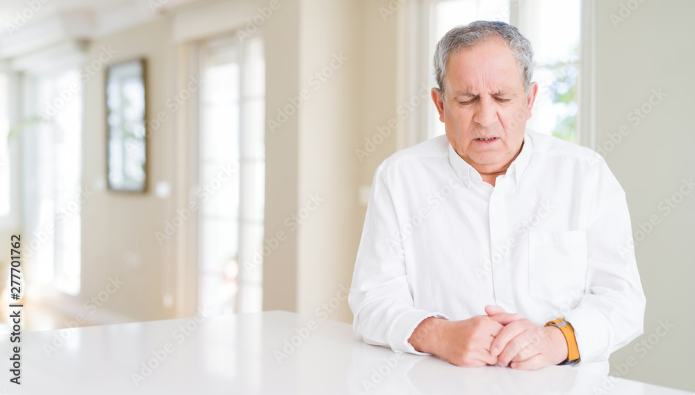Handsome senior man at home depressed and worry for distress, crying angry and afraid. Sad expression. Handsome senior man at home depressed and worry for distress, crying angry and afraid. Sad expression.