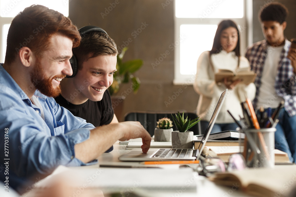 University students doing group study in library, using laptop