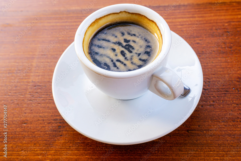 Fototapeta premium white cup of hot coffee on table