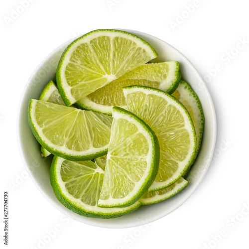 Slices lime in bowl isolated on white background. Top view
