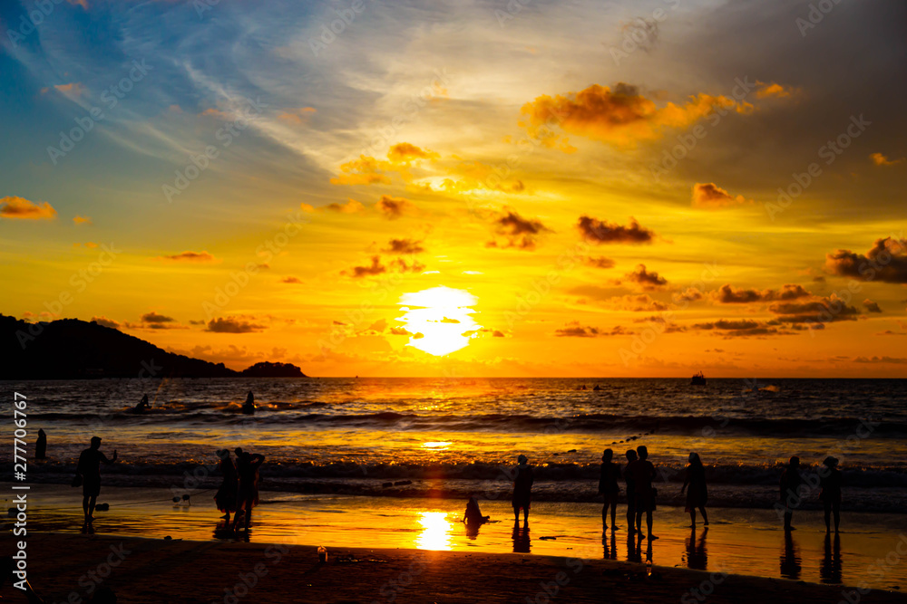 People are playing at the beach and waiting to watch the sunset. People are playing at the beach and waiting to watch the sunset.
