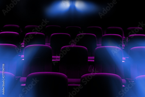 empty movie theater with purple seats with flare light rays from projector