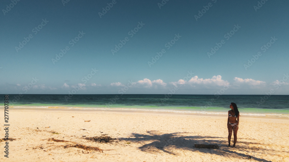 Palm trees and the girl on the white beach in Tulum caribbean, Mexico