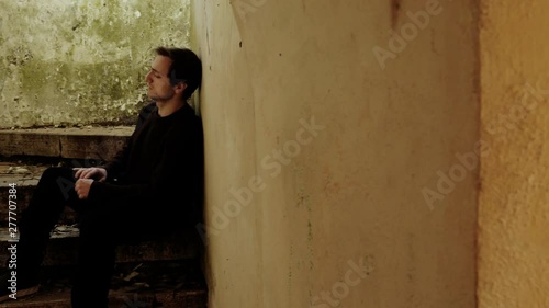 lonely sad thoughtful man sitting in abandoned building thinks of ex girlfiend photo