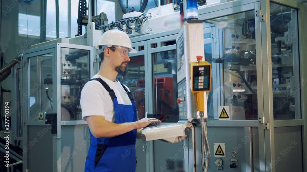 Plant worker is managing a control board in the manufacturing unit Plant worker is managing a control board in the manufacturing unit