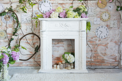 White decorative fireplace with flowers and candles.