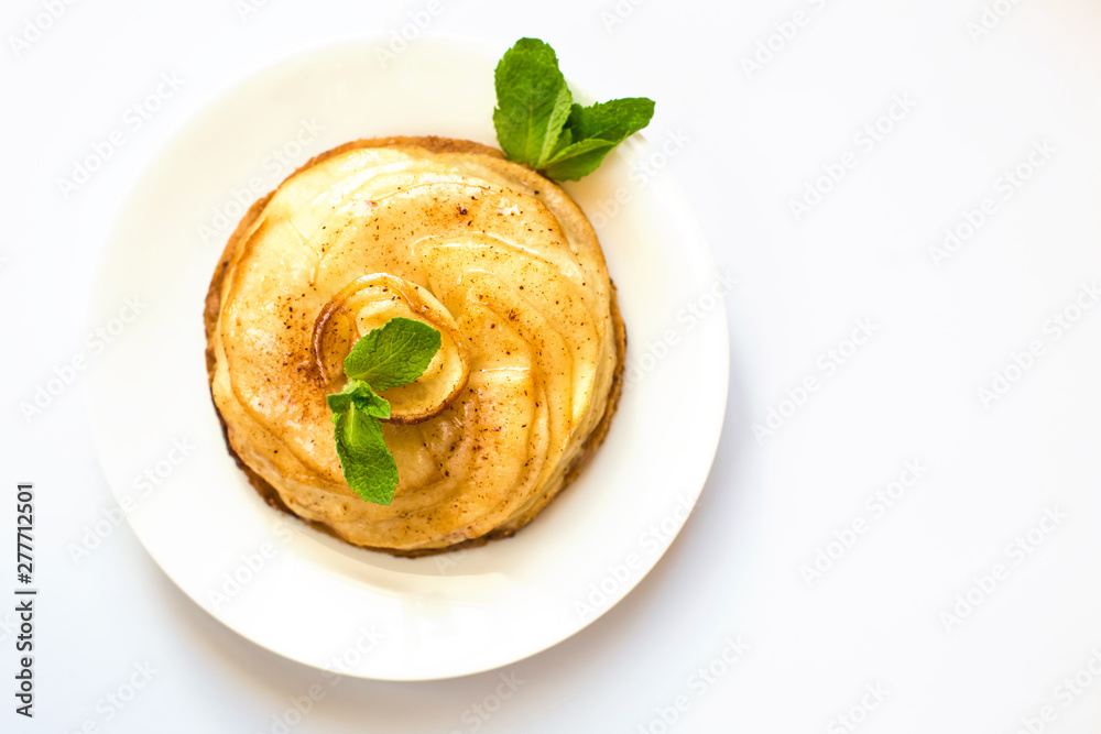 Fresh appetizing round cake made of apple charlotte with mint leaves close-up on a white background. Isolate Fresh appetizing round cake made of apple charlotte with mint leaves close-up on a white background. Isolate