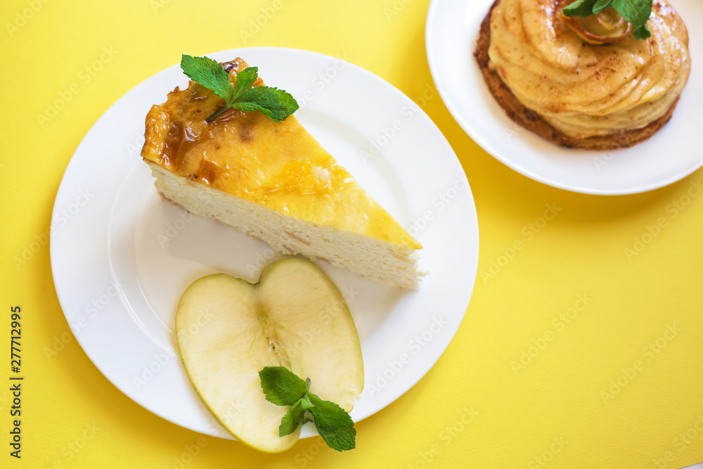 Apple and cottage cheese pie and a charlotte pie of yellow and green apples on white plates stand on a yellow background