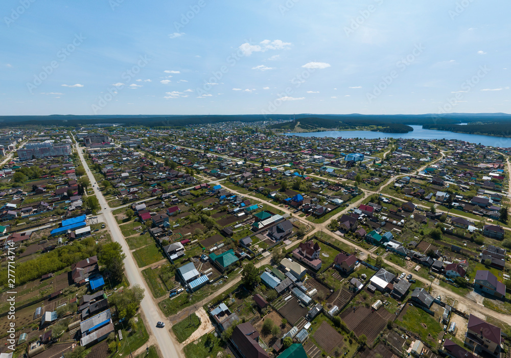 Sysert city. Russia. Aerial. City with low private houses, long streets and pond. Sunny, summer