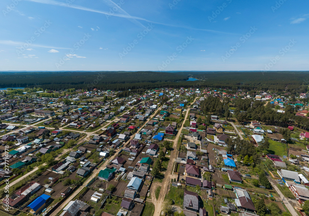 Sysert city. Russia. Aerial. City with low private houses and long streets. Sunny, summer