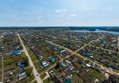 Fototapeta Naklejka Na Ścianę i Meble -  Sysert city. Russia. Aerial. City with low private houses, long streets and pond. Sunny, summer