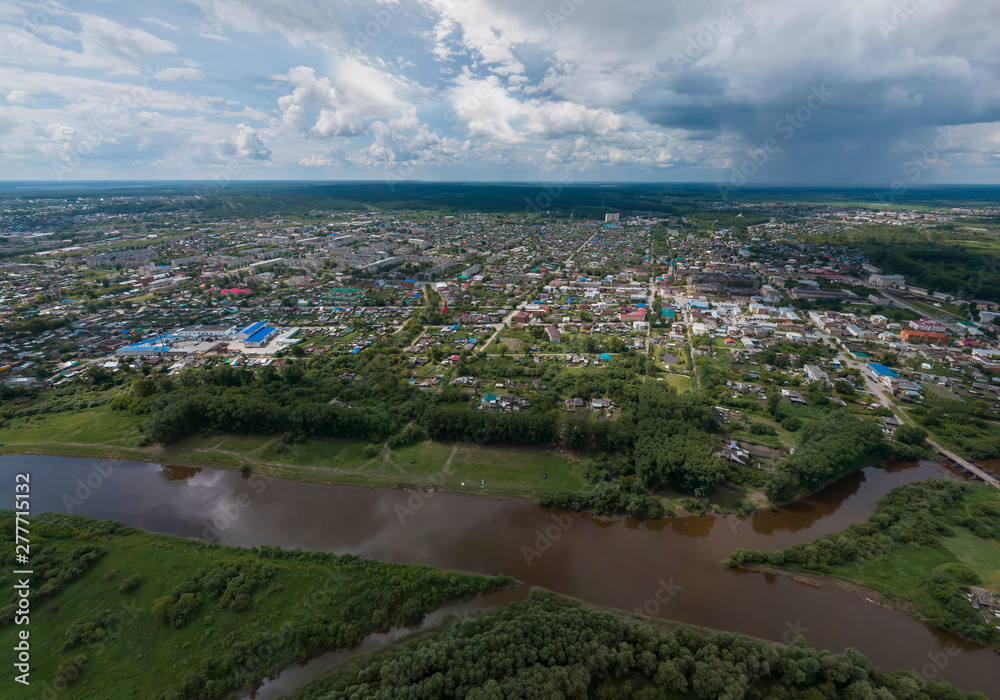 Irbit city and river. Russia. Aerial. Summer, cloudy.  A lots of trees and grass