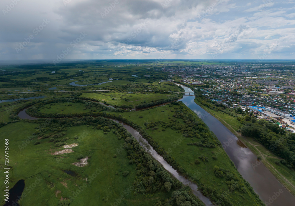 Irbit city and river. Russia. Aerial. Summer, cloudy. A lots of trees and grass Irbit city and river. Russia. Aerial. Summer, cloudy. A lots of trees and grass