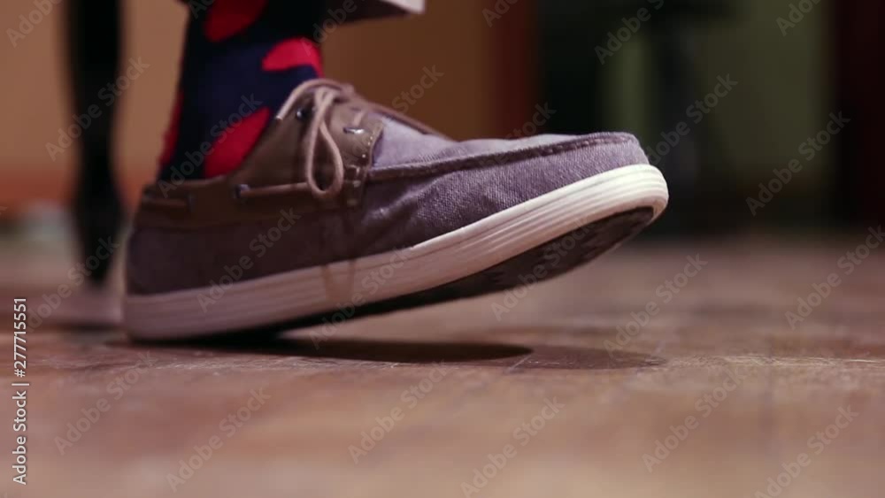 Foot of musician taps the wooden floor on stage rhythmically following melody beat