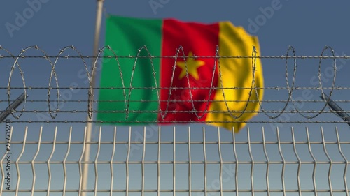 National flag of Cameroon behind barbed wire fence. Conceptual loopable 3D animation photo