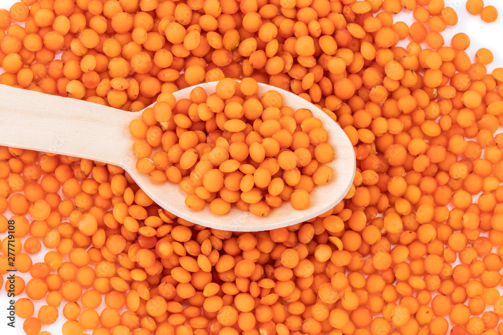 red lentils on wooden spoon isolated on white background red lentils on wooden spoon isolated on white background