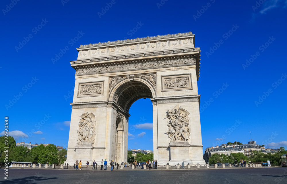 Perfect view of the Arc de Triomphe seen from the east with the two sculptures Le Départ and Le Triomphe on a nice sunny day with a beautiful blue sky. It is one of the most famous monuments in Paris.