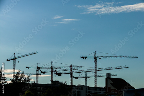 Silhouette of construction tower crane against blue evening sky