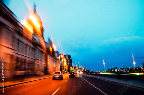 Driving at dusk through the streets of Dublin City, Ireland. Speed blur of orange lights and blue sky