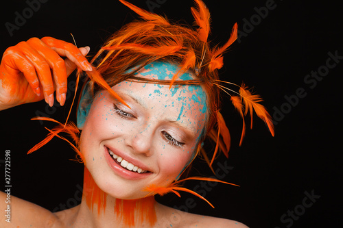 Tablou canvas Portrait of a beautiful model with creative make-up and hairstyle using orange f