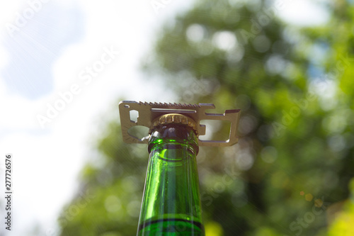 Glass transparent green glass bottle. With a cork and a bottle opener.