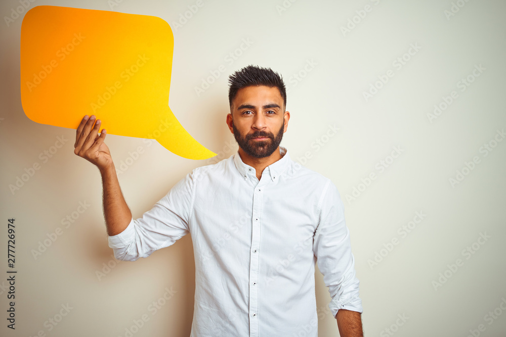 Young arab indian hispanic man holding speech bubble over isolated white background with a confident expression on smart face thinking serious - obrazy, fototapety, plakaty 