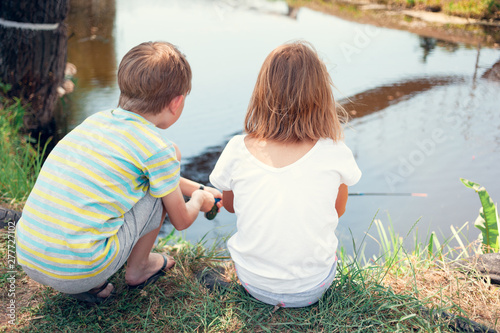 Fishing. Children fishingon the bank of the river in a hot, summer day. photo