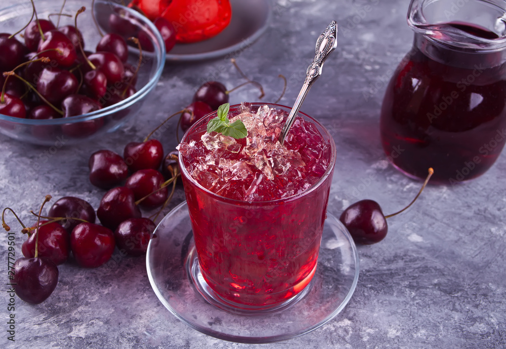 Glass with fresh homemade cherry sweet iced tea or cocktail, lemonade with mint. Refreshing cold drink. Summer party. Glass with fresh homemade cherry sweet iced tea or cocktail, lemonade with mint. Refreshing cold drink. Summer party.
